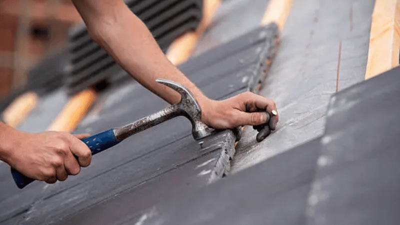 Close-up of metal roofing panels being secured, highlighting strength, longevity, and weather protection benefits.